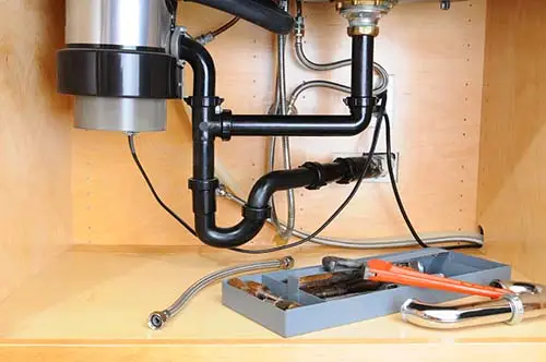 The piping under a kitchen sink